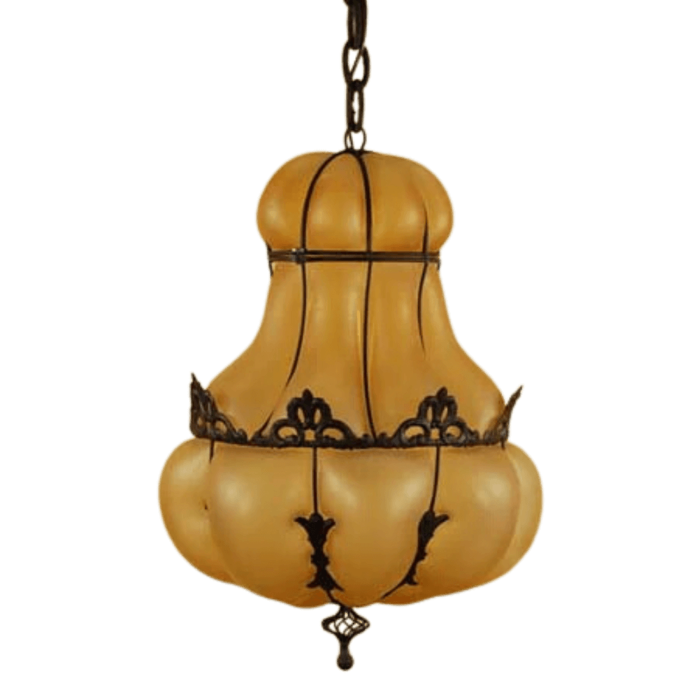 An elegant pendant light featuring a rounded, amber glass shade with intricate wrought iron scrollwork. The design evokes warmth and sophistication, ideal for enhancing any space.