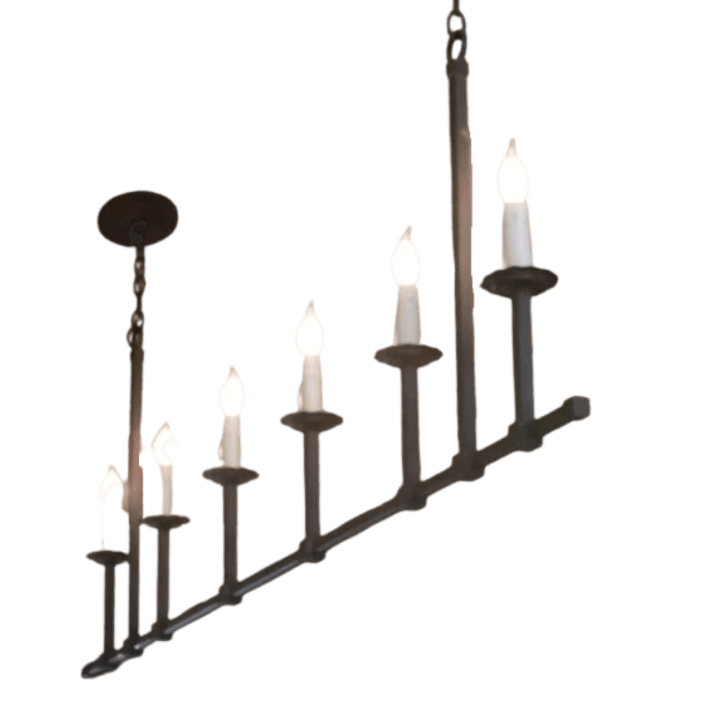 A graceful wrought iron chandelier featuring six candle-like lights on a linear frame. The design combines elegance and rustic charm, ideal for enhancing any space.