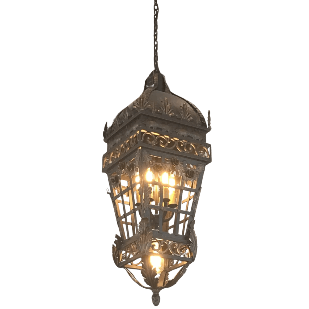A decorative pendant light featuring intricate wrought iron detailing and a stylish, ornate design. The fixture showcases multiple bulbs, casting a warm ambiance.