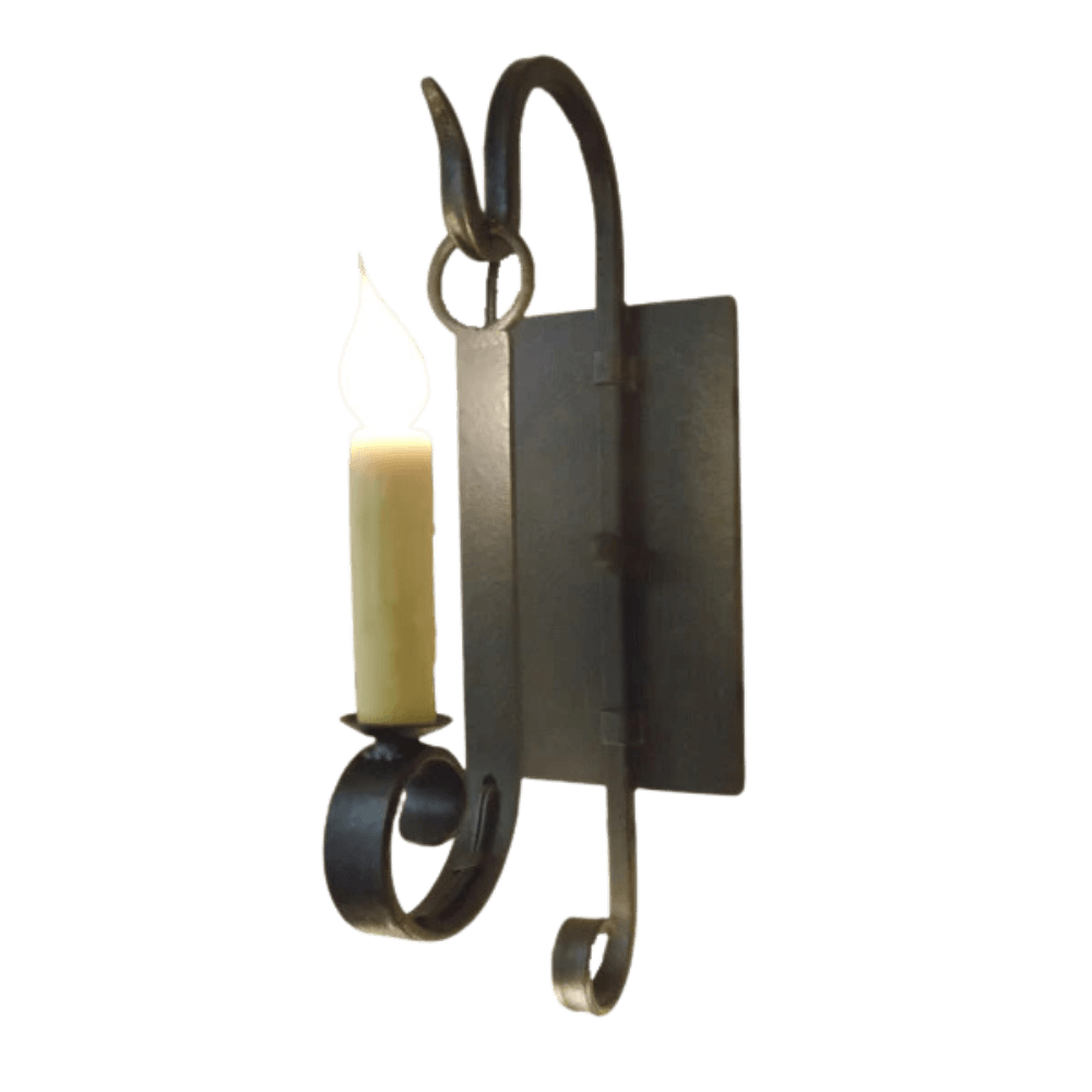 A beautifully crafted wrought iron sconce featuring intricate swirling designs. A single candle holder emits a warm glow, enhancing any space with a touch of elegance and charm.