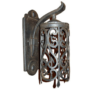 A decorative wrought iron sconce featuring intricate scrollwork and a curved design. The fixture is affixed to a wall, showcasing its elegant craftsmanship and vintage charm.