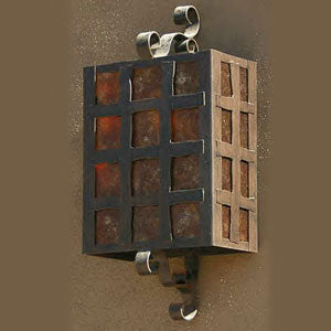 A custom wrought iron sconce featuring a grid pattern design with warm, glowing glass panels. The fixture showcases elegant curls and a rustic finish, adding charm to indoor or outdoor spaces.