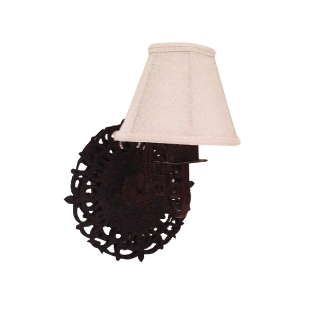 A beautifully designed wall sconce featuring ornate wrought iron detailing and a soft fabric shade, casting a warm glow.