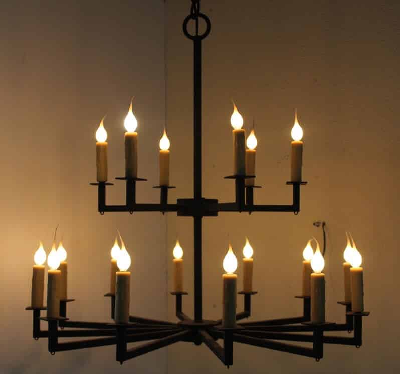 A beautifully crafted wrought iron chandelier showcasing multiple arms adorned with flickering candle-like bulbs, creating an inviting glow.