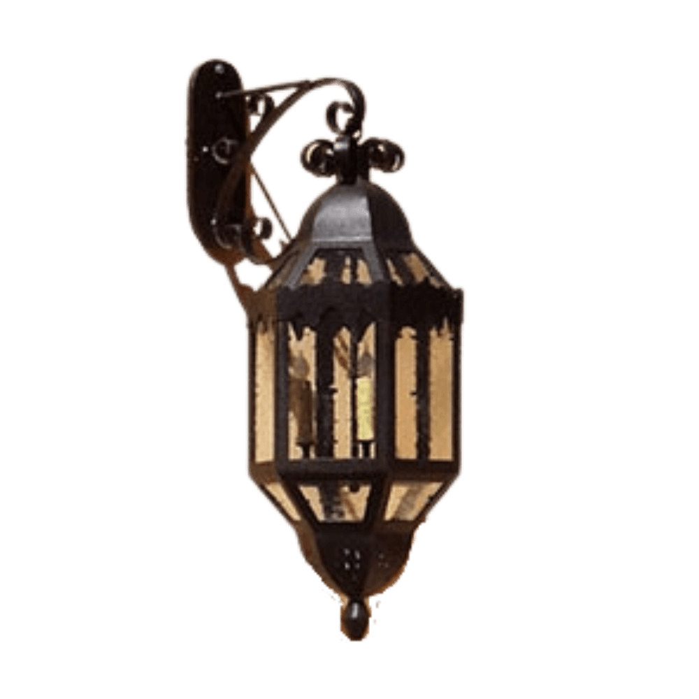 A decorative wrought iron wall sconce featuring an ornate design with glass panels, showcasing its warm glow. Ideal for adding traditional charm to any space.