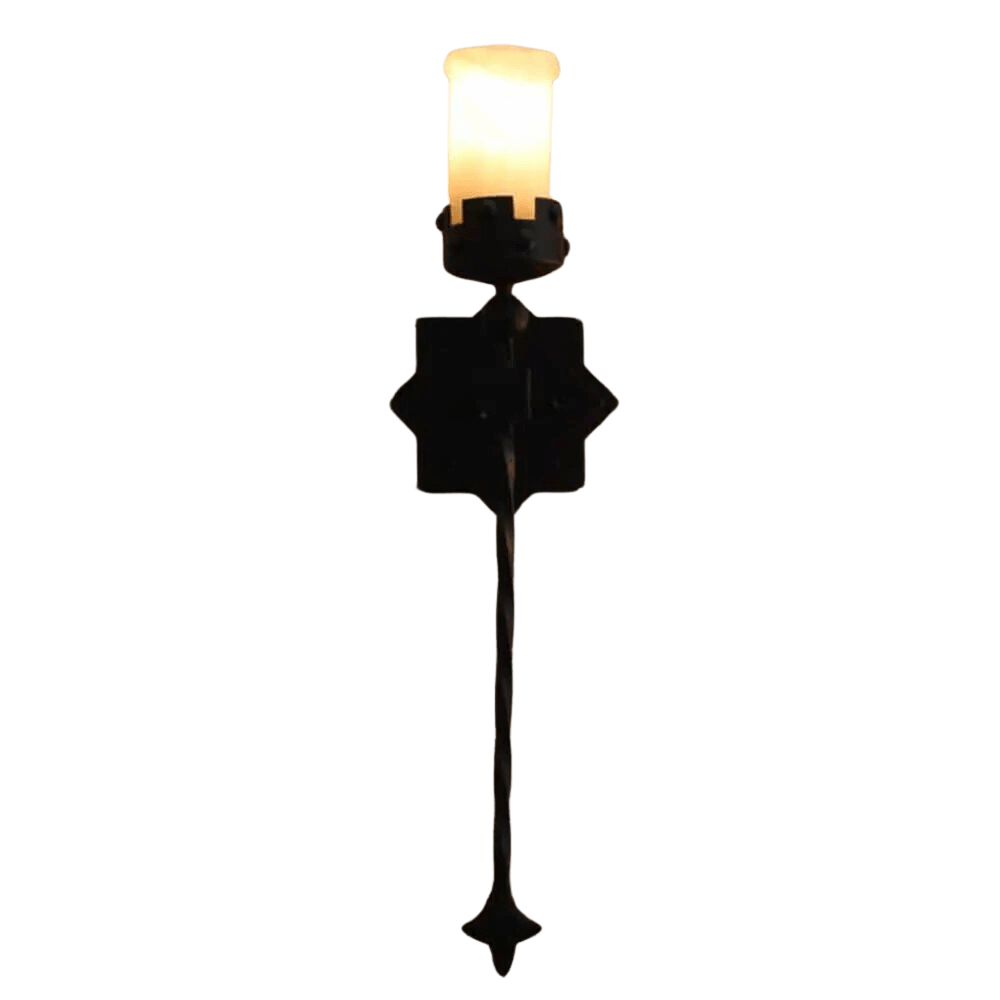 A wrought iron wall sconce featuring an elegantly twisted stem and a decorative backplate, topped with a warm, glowing candle-style light.