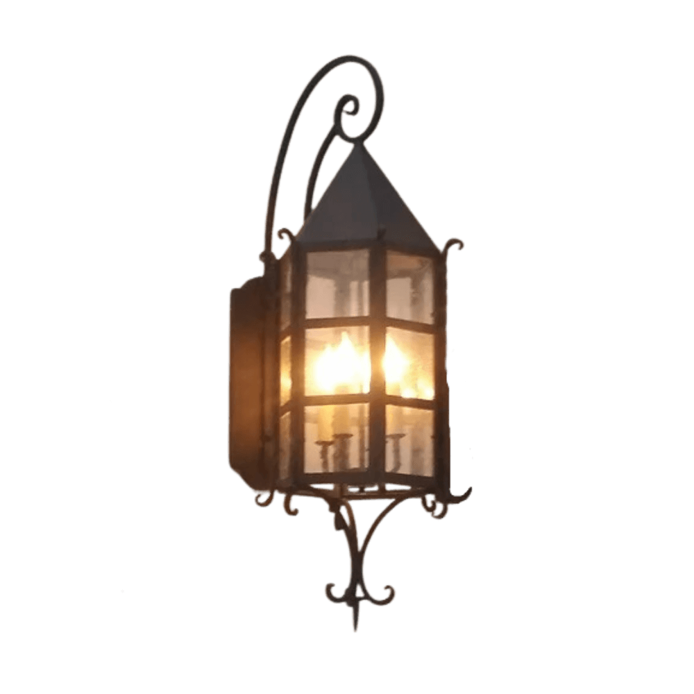 This decorative wall sconce features a beautifully crafted wrought iron frame with a pointed roof and glass panels. It illuminates from within, showcasing multiple candle-like bulbs, perfect for adding warmth and character to any space.