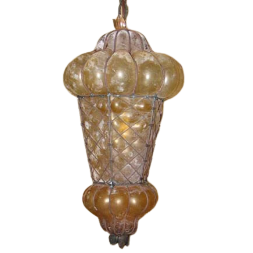 A beautifully crafted wrought iron pendant featuring a rounded top and elaborate glass detailing. The warm, golden hues create a cozy ambiance, showcasing intricate mesh patterns that enhance its elegance. Perfect for adding a touch of artistry to any space.