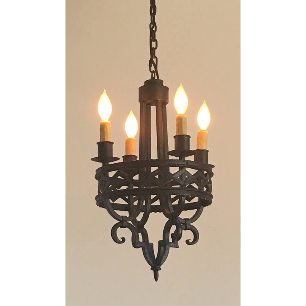 A beautifully crafted wrought iron chandelier featuring five elegant candle-style lights. The intricate design showcases a mix of curves and geometric patterns, enhancing any room's ambiance with warmth and artistry.