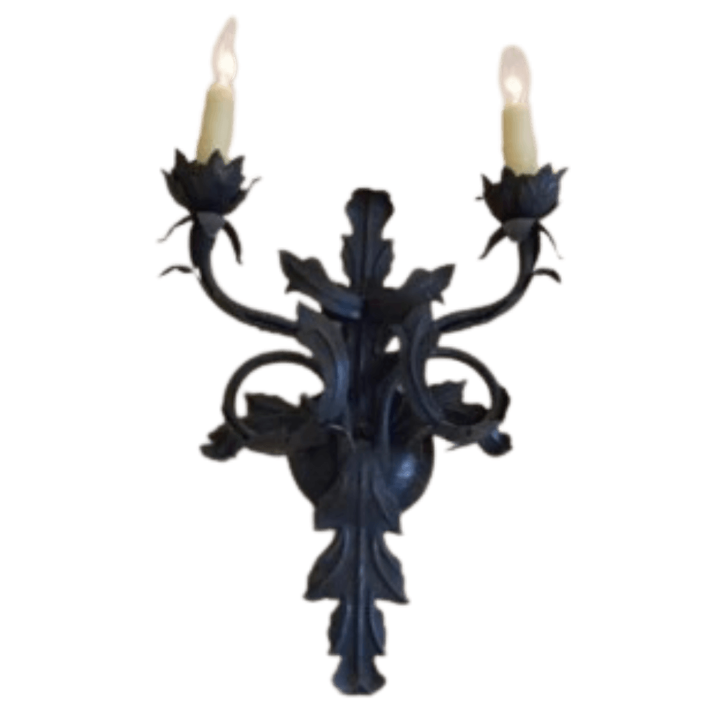 Wrought iron wall sconce featuring two elegant candle holders shaped like flowers, adorned with intricate scrollwork and leafy details, creating a sophisticated and artistic lighting option.