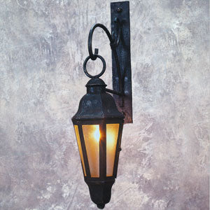 A wall-mounted wrought iron sconce featuring a classic, elegant design with glass panels that emit a warm glow. The sturdy hardware adds a timeless charm, making it perfect for enhancing any interior or exterior space.