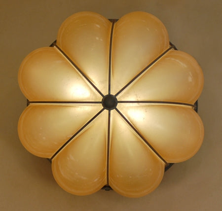 A decorative ceiling fixture featuring a floral design with eight translucent glass petals, softly illuminating the space. The wrought iron frame adds an elegant touch, perfect for enhancing any room's ambiance.