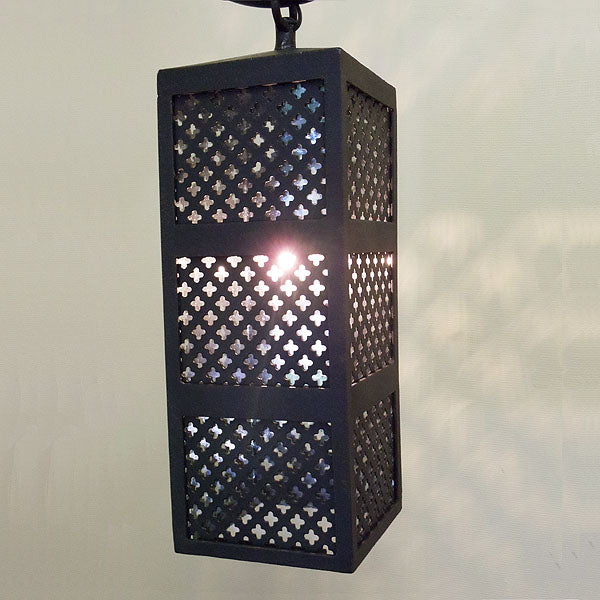 A rectangular wrought iron pendant featuring intricate cut-out patterns, casting beautiful light patterns. Ideal for adding elegance to any space.