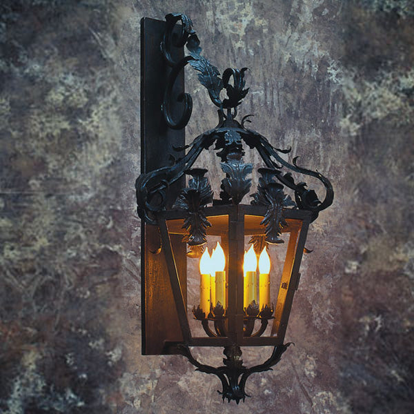Intricate wrought iron wall sconce featuring elegant scrollwork and floral details, illuminating four faux candle lights for a warm ambiance.