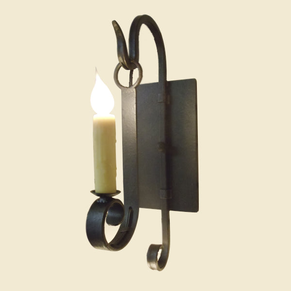 A decorative wall sconce featuring elegant wrought iron accents, showcasing a flickering candle design on a sleek backplate, perfect for adding warmth to any space.