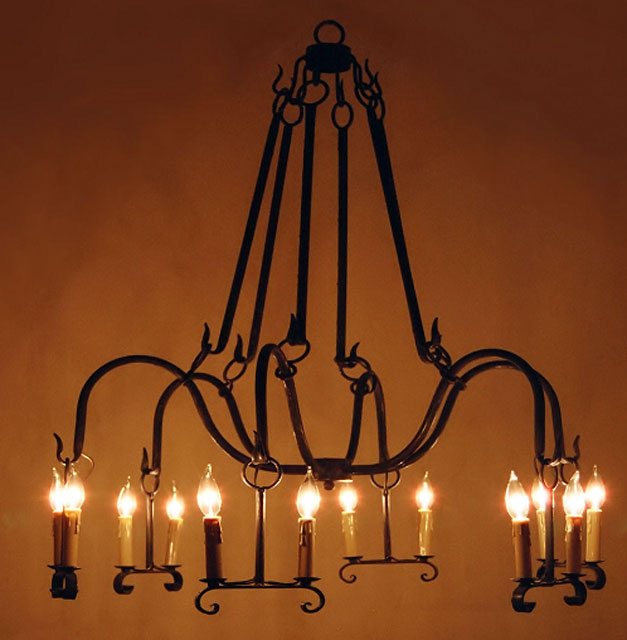A beautifully crafted wrought iron chandelier featuring elegant curved arms and multiple candle-style lights. The intricate design enhances any space, creating a warm and inviting atmosphere.