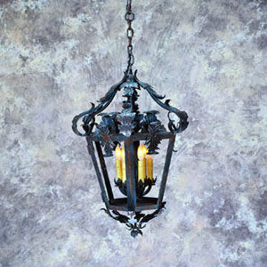 A beautifully crafted wrought iron pendant light features intricate scrollwork and leaf designs, housing three glowing bulbs. The elegant shape and dark finish create a warm and inviting ambiance, perfect for enhancing any space.