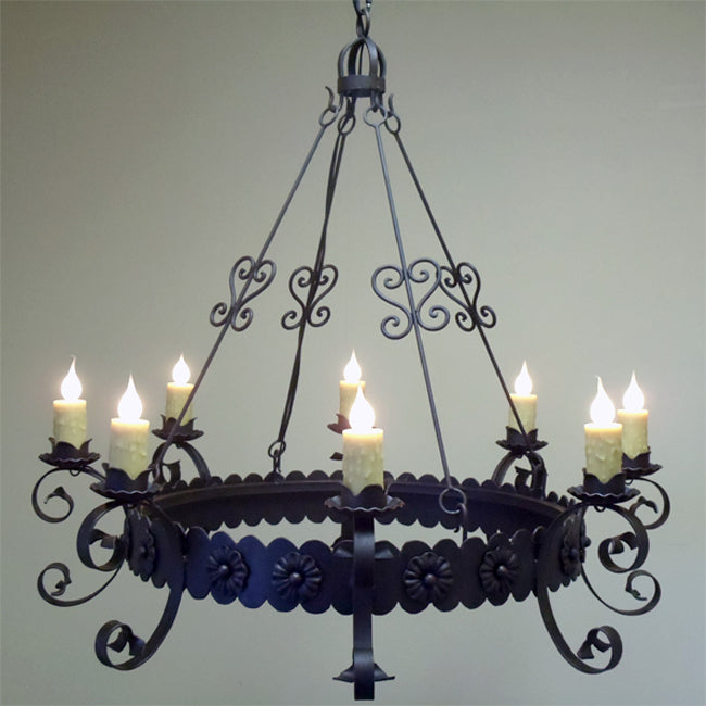 A beautifully crafted wrought iron chandelier featuring elegant curves and floral accents. The design showcases six candle-like lights, creating a warm and inviting ambiance. Ideal for adding a touch of rustic charm to any space.