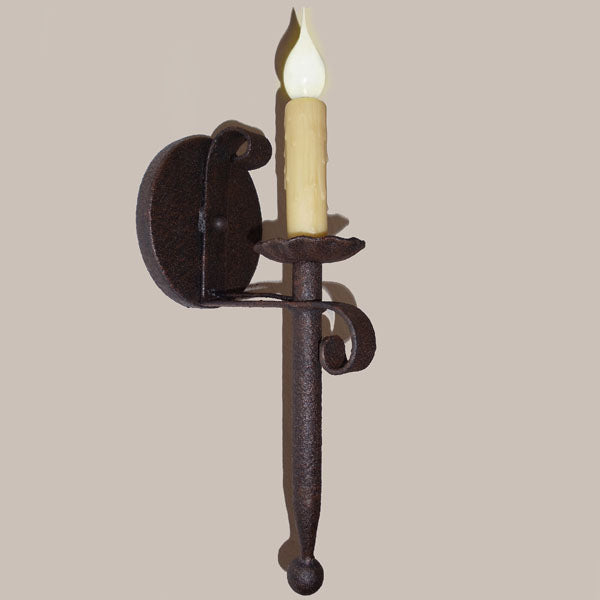 A handcrafted wrought iron sconce featuring a curled design and a tall, flickering candle. The rustic finish enhances its classic appeal, perfect for adding warmth and charm to any space.