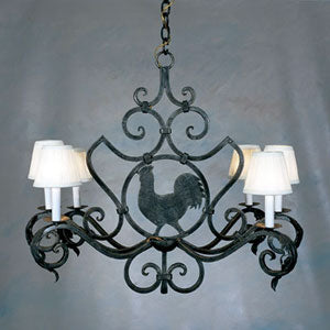 A beautifully crafted wrought iron chandelier featuring elegant curves and a central rooster motif. Six candle-style lights with white shades enhance its charm, perfect for adding sophistication to any space.