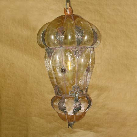 A beautifully crafted pendant light featuring a smooth, rounded shape with ornate metalwork details and a vintage glass finish, enhancing any space with warm, inviting illumination.