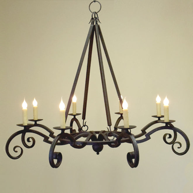 A beautifully crafted chandelier featuring swirling wrought iron arms with six candle holders. The design includes elegant curves and a rustic finish, adding a warm ambiance to any space. Perfect for enhancing dining areas or living rooms.