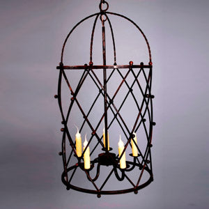 A decorative wrought iron chandelier featuring an intricate crisscross design. It includes four candle-like lights, providing a warm ambiance while showcasing artisanal craftsmanship.
