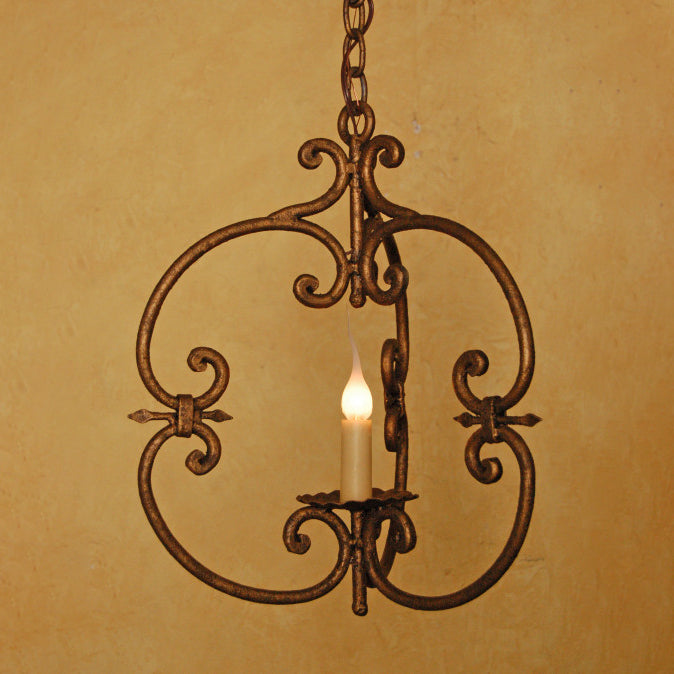 A decorative wrought iron chandelier featuring elegant scrollwork and a candle-style light, suspended by a chain against a warm, textured background.
