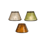 Three distinct wrought iron light shades showcase a blend of natural hues: one in muted beige, another in soft green, and the last in warm amber. Each shade features a textured finish, highlighting the craftsmanship of the designs. Perfect for adding a touch of rustic elegance, they can enhance various lighting fixtures within a home.