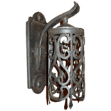 Elegant wrought iron sconce featuring intricate scrolling patterns. The fixture showcases a beautiful blend of craftsmanship and style, perfect for enhancing any interior space.
