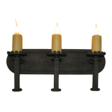 A rustic wrought iron sconce featuring three candle holders with warm, flickering lights. The design includes artistic detailing, enhancing any space with a touch of elegance and charm.