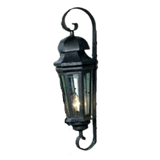 A wrought iron wall sconce featuring an elegant lantern design with glass panels. The fixture is adorned with a curling mount, providing a classic touch to any space.
