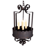 Elegant wrought iron hanging fixture featuring three tall candle lights, adorned with decorative curves and a scalloped edge, adding charm to any space.