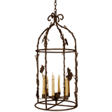 An ornate wrought iron chandelier featuring a curved frame adorned with vines and leaves. Five candle-like bulbs emerge from a central base, creating an inviting ambiance. The intricate design showcases craftsmanship, adding elegance to any space.