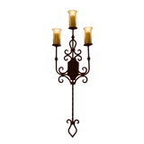 A decorative wrought iron wall sconce featuring three candle-style lights atop intricate scrolling details. The elegant design enhances any space with a warm, inviting glow.