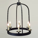 A handcrafted wrought iron chandelier featuring five candle-like lights, elegantly suspended by twisted rods, casting a warm and inviting glow.