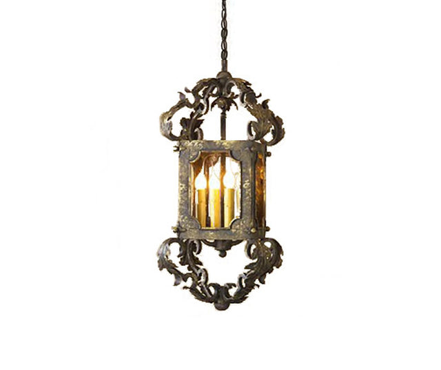 An ornate wrought iron pendant featuring intricate scrollwork and a rectangular frame, illuminating with warm light from multiple bulbs.